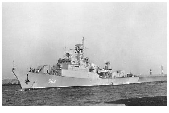 Eine Fregatte mit der Bordnummer 693 läuft zwischen den Molenköpfen in den Hafen ein, aufgenommen von der Seite in voller Länge